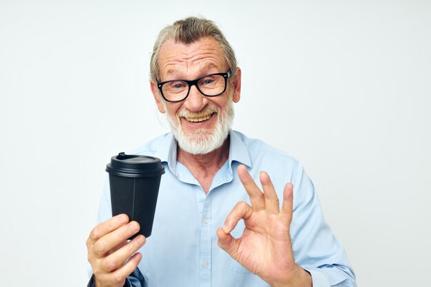 Old man gestures with his hands a glass of drink isolated background