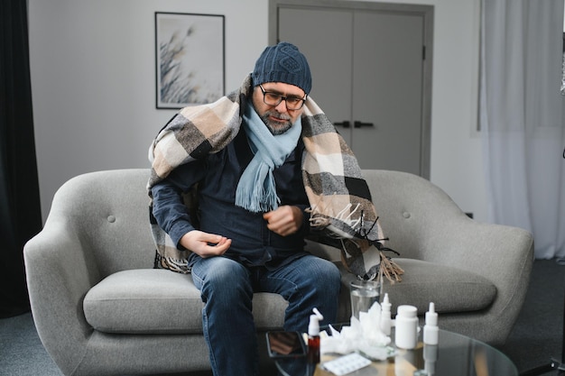 old man get a cold and sneeze with tissue paper at home