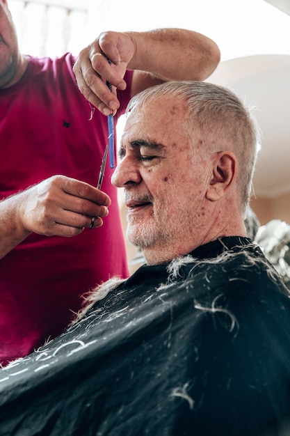 Photo old man getting a haircut
