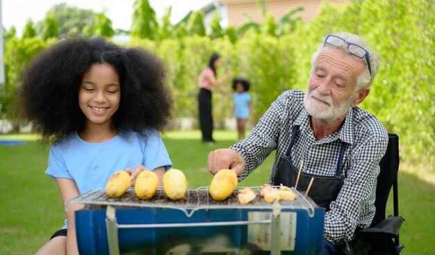 an old man and a girl are playing with some food