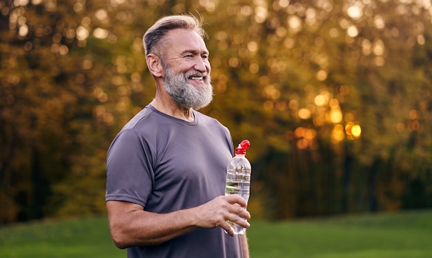 The old man holding bottle of a water