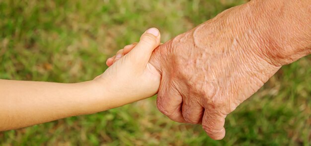 Old man holding childs hands selective focusPeople