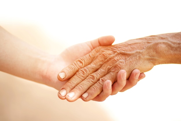 Photo an old man and a kid holding hands together