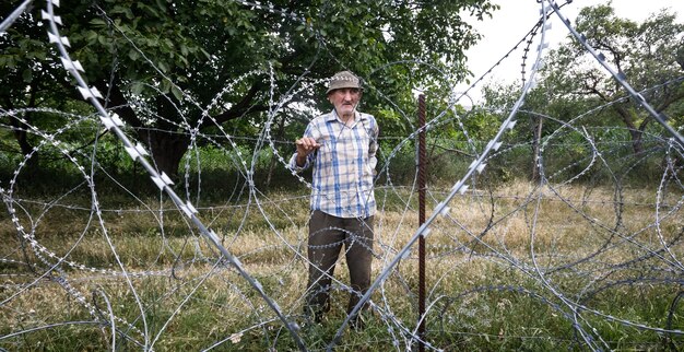 Old man on local stand near barbed wire on the separation line with occupied Tskhinvali region Georgia's de-facto border with its breakaway region of South Ossetia