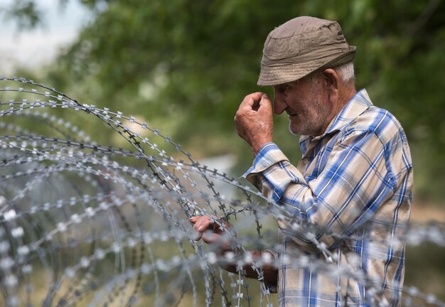 Old man on local stand near barbed wire on the separation line with occupied Tskhinvali region Georgia's de-facto border with its breakaway region of South Ossetia