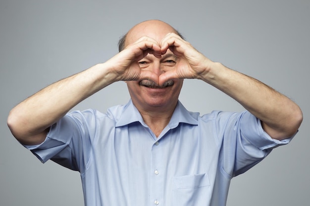 Old man making out of hands heart Doing charity work take care of the health or being in love
