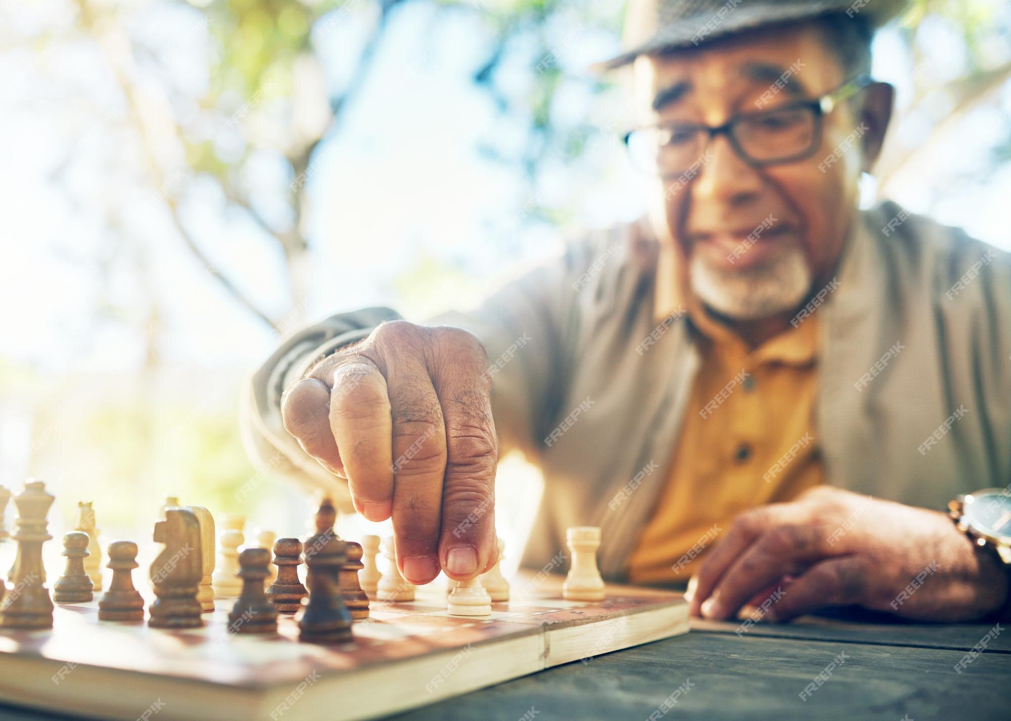 Hand Of A Man Taking A Chess Piece To Make The Next Move In A Chess Game.  Close Up. Spring Day Outside. Stock Photo, Picture and Royalty Free Image.  Image 198493640.