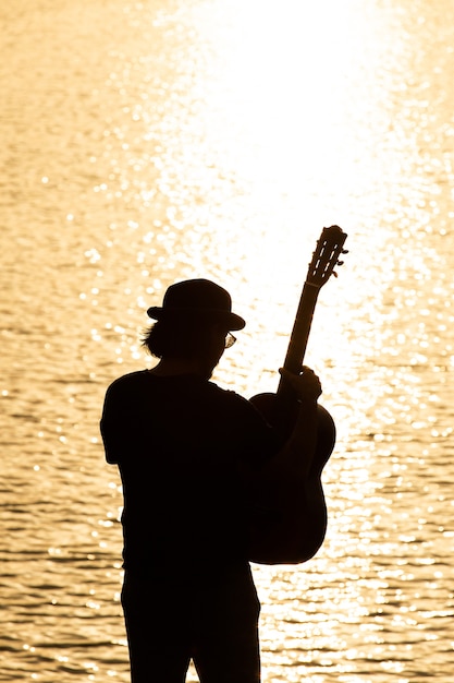 Old man playing on acoustic guitar - outdoor