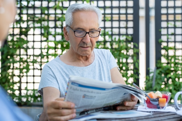 Old man reading newspaper