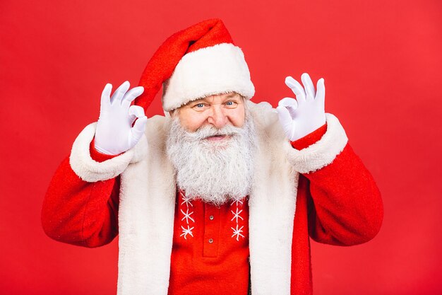 old man in Santa Claus costume isolated on red background