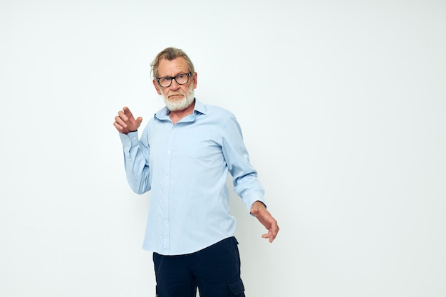 Old man in shirt and glasses posing emotions light background