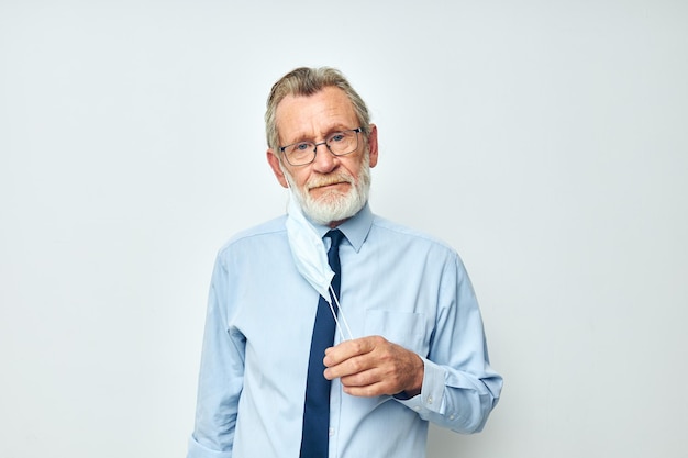 Vecchio in camicia con cravatta medica maschera di sicurezza sfondo chiaro