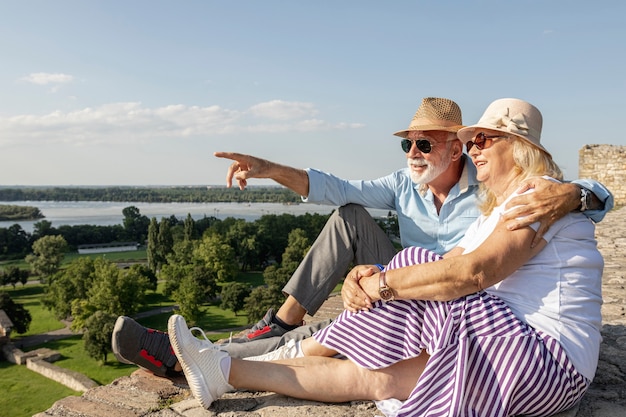 Old man showing woman a  view