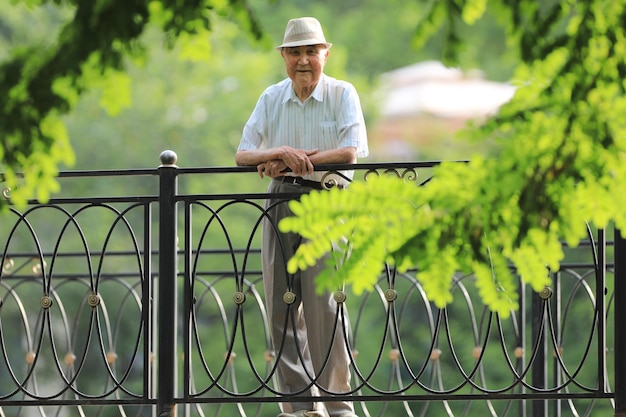 old man smiles and rests outdoors in summer