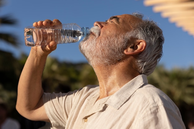 Photo old man struggling with high temperature