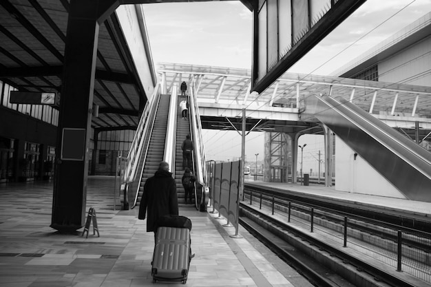 Old man walking with bag at train station