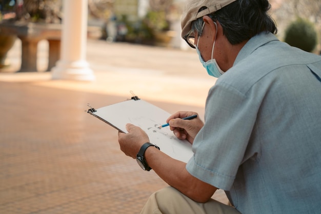 Old man wearing medical mask painter creating picture of boy
art talent craft hobby occupation