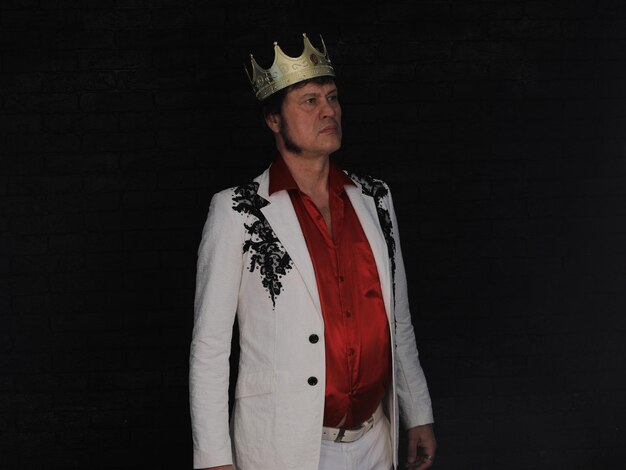 Photo old man in a white jacket with a crown