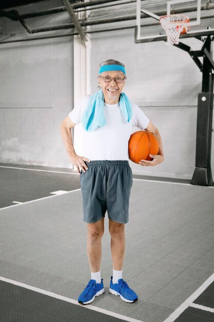 Photo old man with basketball in the stadium