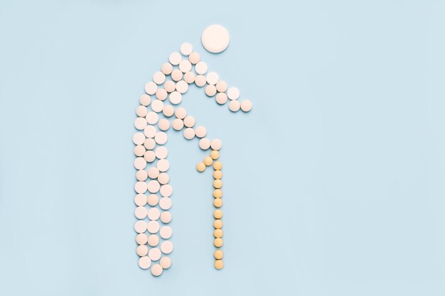 Old man with a cane made of pills on a blue background