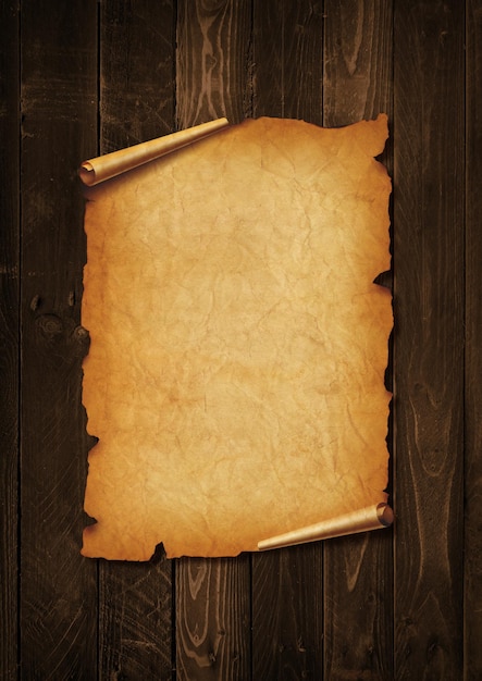 Old mediaeval paper sheet Parchment scroll isolated on a wood board background