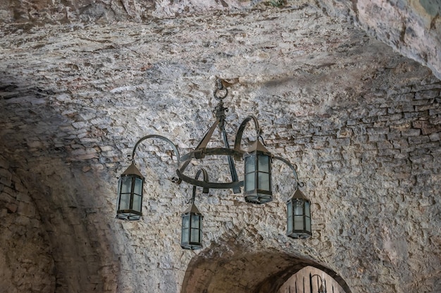 An old medieval chandelier hangs in the center of the dungeon