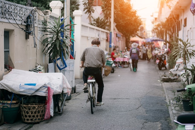 Old men are cycling in the village.