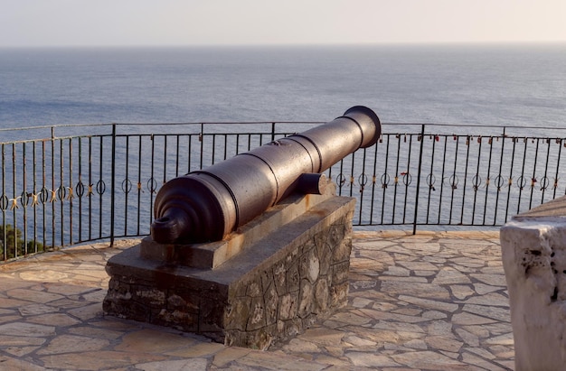 Foto vecchio cannone di metallo contro il mare