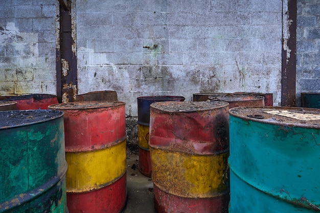 Old metal chemical tanks at sunset sky, dirty oil steel drums,\
environment, chemical disposal