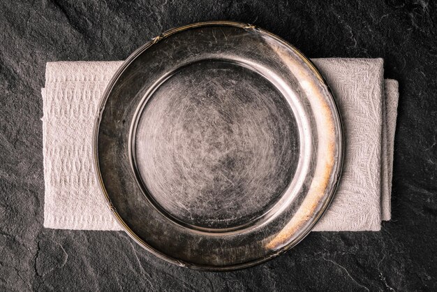 Old metal plate on the dark stone table top view