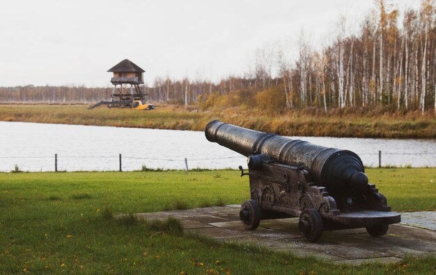 Old military pistol. Old cannon on the lake