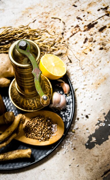 Old mill with spices and herbs on the tray.