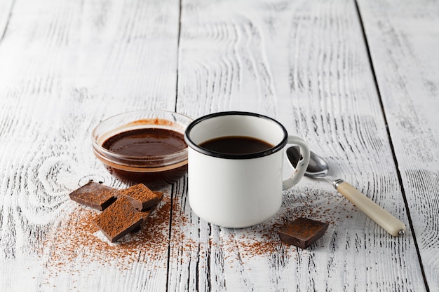 カフェの木製テーブルで温かい飲み物と古いマグカップ