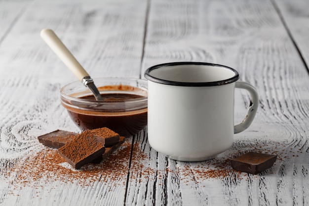 カフェの木製テーブルで温かい飲み物と古いマグカップ