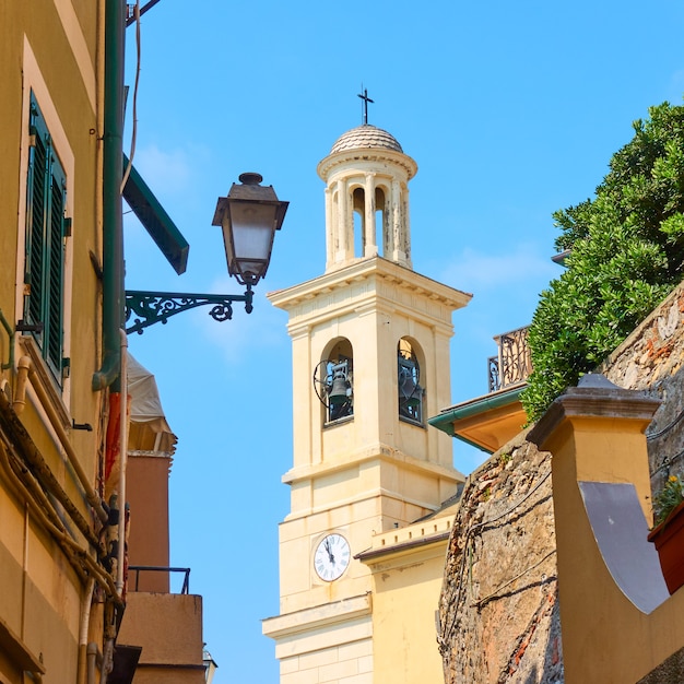 Old narrow street in Boccadasse district in Genoa and bell tower of Church of St. Anthony of Boccadasse, Italy