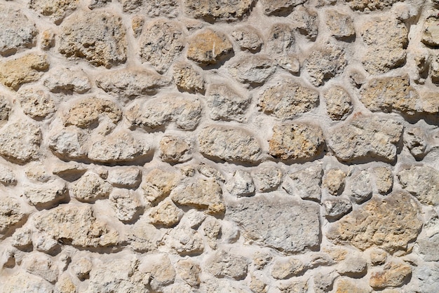 Old natural stone grey beige brown wall of medieval brick horizontal grunge background