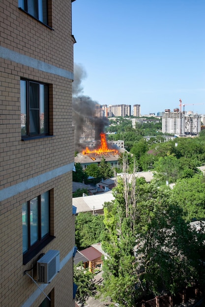 Old and new an old abandoned building is burning against the\
background of new buildings