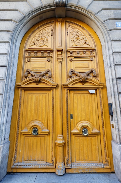 Old ornate door in Paris typical old apartment buildiing