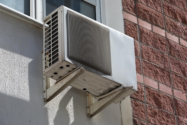 Old outdoor air conditioner unit hanging outside the building