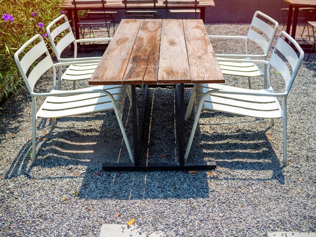 Old outdoor wooden dining table on gravel floor