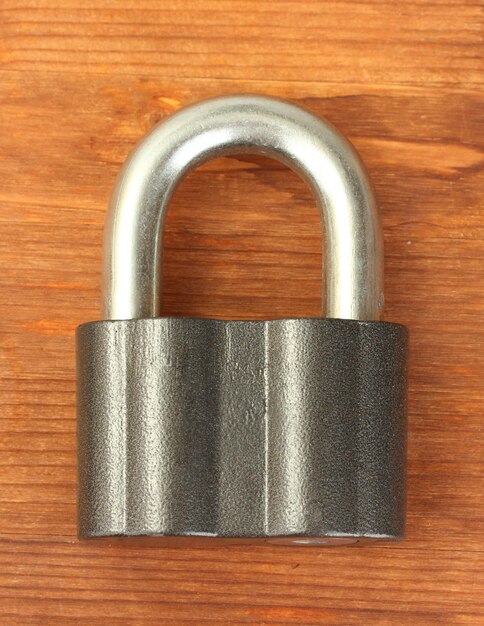 Old padlock on wooden background closeup