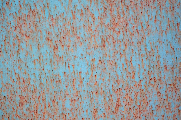 An old painted sheet of iron covered with rust