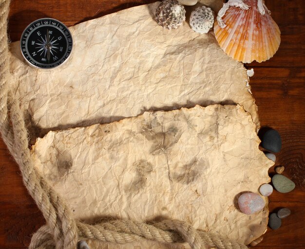 Old paper compass and rope on a wooden table