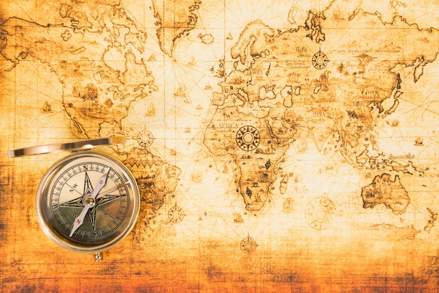 Old paper map with an ancient compass on it. Vintage travel background