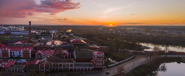 日没時の秋にベラルーシの古い製紙工場。上からの眺め