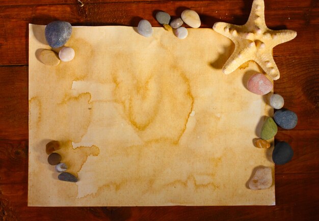 Фото Старая бумажная морская звезда и камни на деревянном столе
