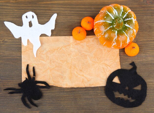 Photo old paper with halloween decorations on grey wooden background