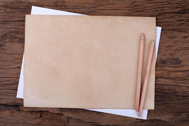 Old paper with pencil on wooden table