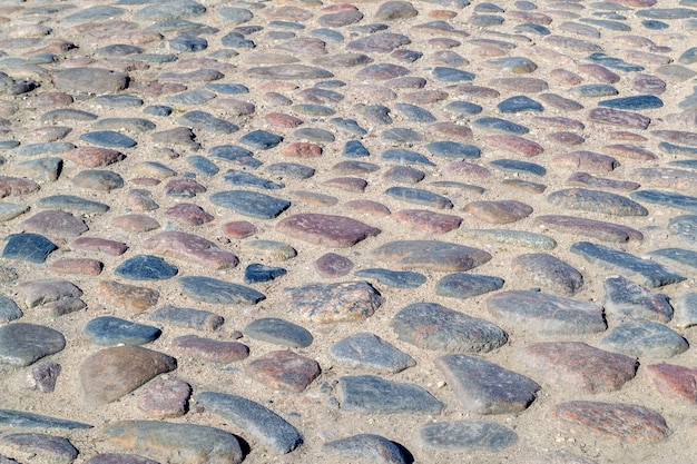 Foto la vecchia pavimentazione. pietre rotonde pietre per lastricati sulla strada. strada di pietre