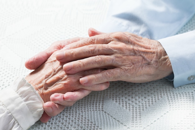 Old people holding hands. Closeup.